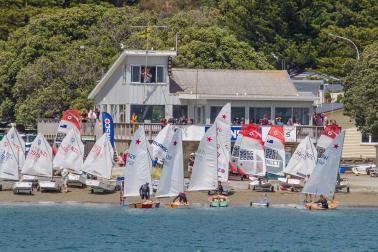 small boats in front of a waterfront yacht club building